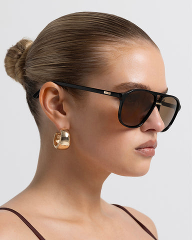 Oversized women's aviator sunglasses with a, flat-top brow bar, keyhole cut, double bridge, and slim arms.