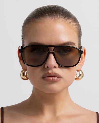 Oversized women's aviator sunglasses with a, flat-top brow bar, keyhole cut, double bridge, and slim arms.