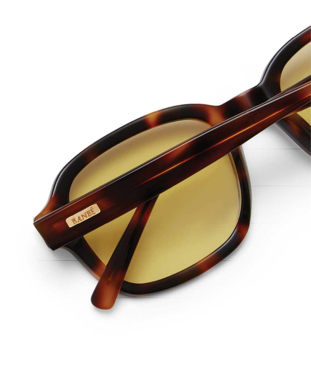 Sunglasses with tortoiseshell frame and yellow lenses on a white background