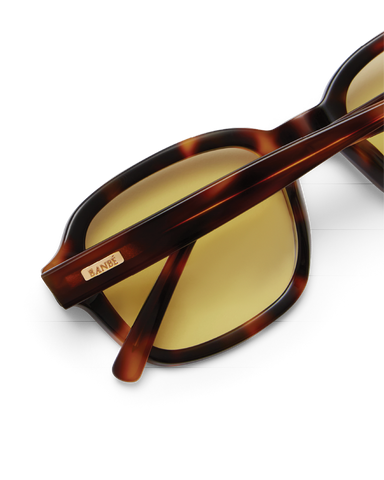 Sunglasses with tortoiseshell frame and yellow lenses on a white background