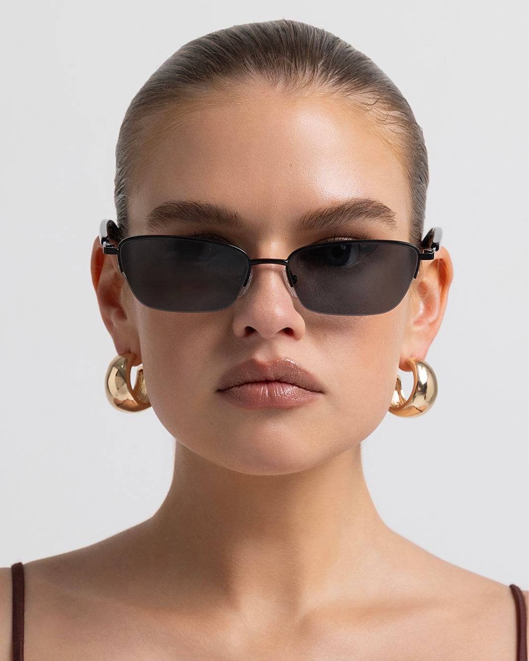 Women’s metal cat-eye sunglasses with UV protection, thin frame, dark tinted lenses, front view on model