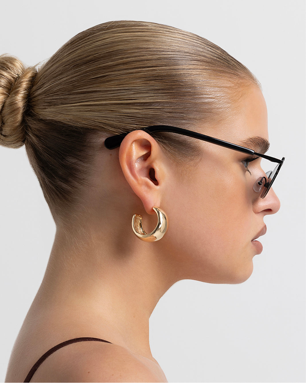 Women’s metal cat-eye sunglasses with UV protection, thin frame, dark tinted lenses, side view on model