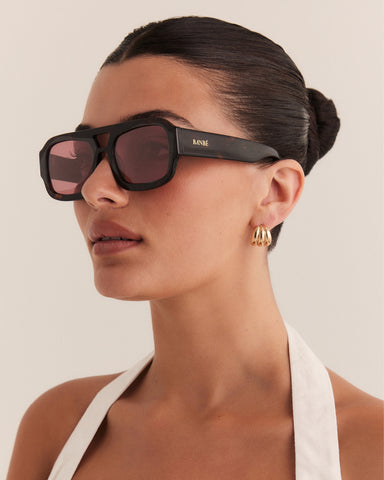 Female wearing modern aviator sunglasses with square acetate tortoiseshell frame and polarised lenses featuring gold embossed logo detail side view.