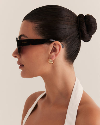 Female wearing modern aviator sunglasses with square acetate tortoiseshell frame and polarised lenses featuring gold embossed logo detail side view.