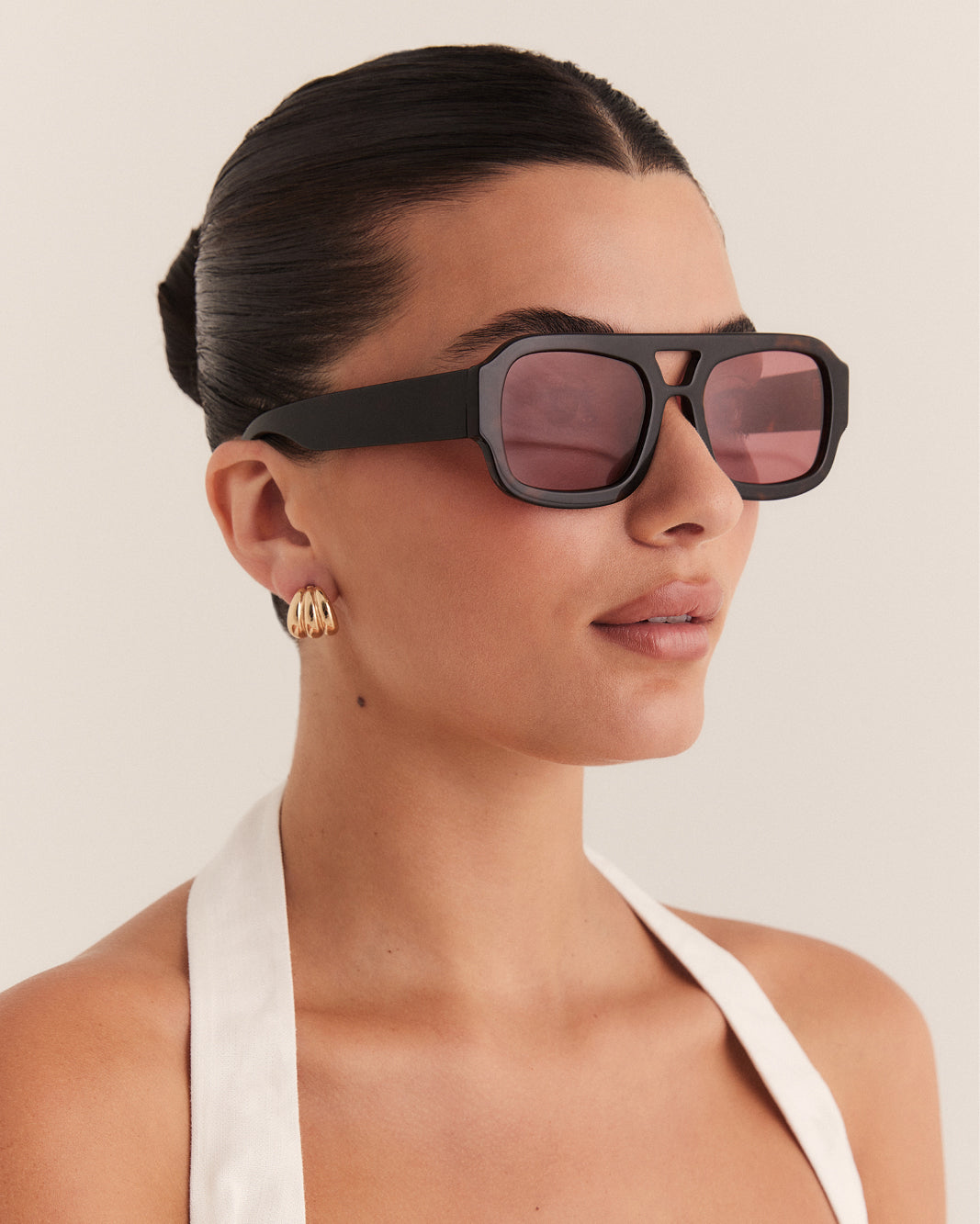 Female wearing modern aviator sunglasses with square acetate tortoiseshell frame and polarised lenses featuring gold embossed logo detail side view.