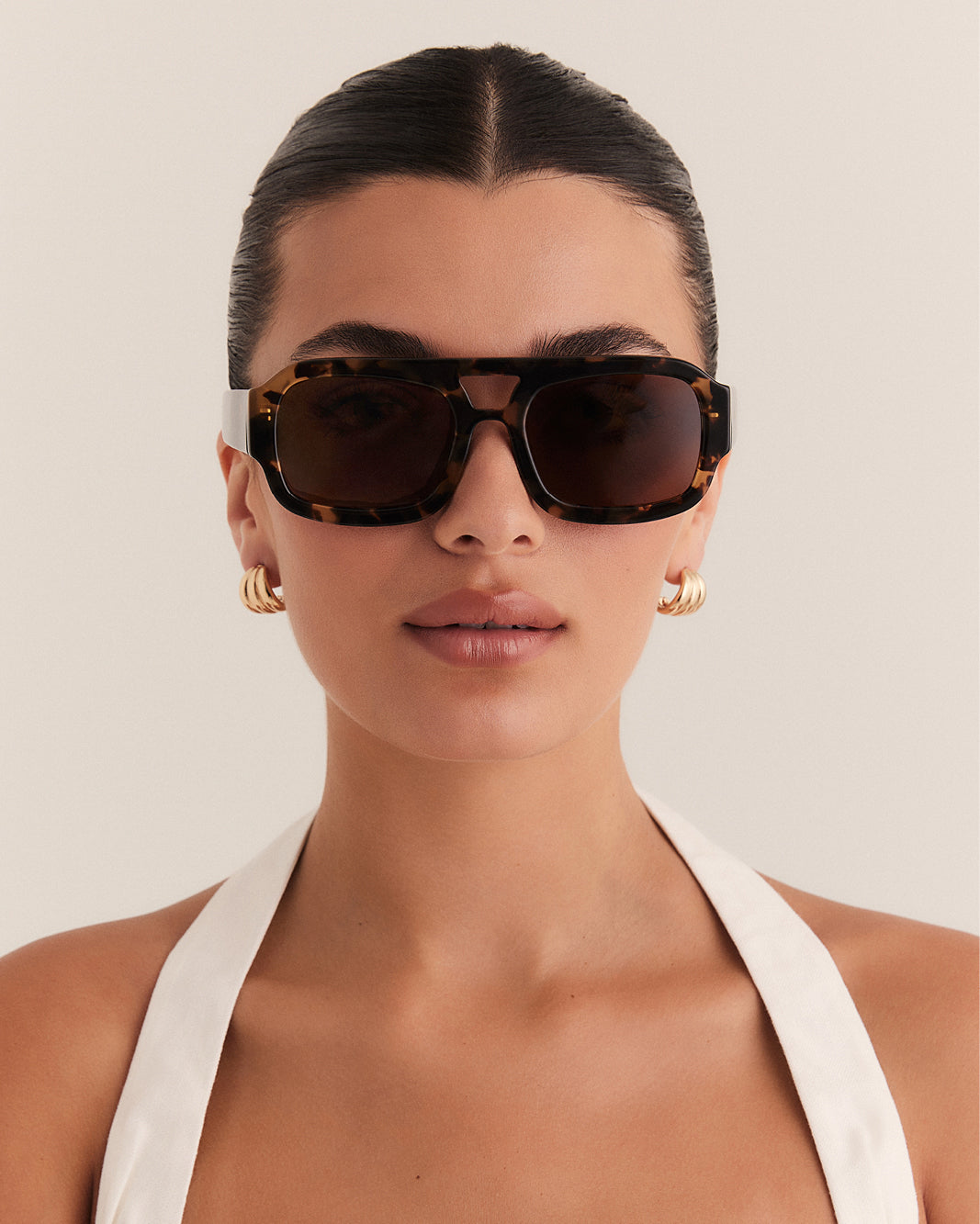Female wearing modern aviator sunglasses with square acetate tortoiseshell frame and polarised lenses featuring gold embossed logo detail front view.